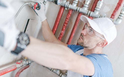 Caucasian Plumber at Work. Worker Checking on a Heating Pipeline.