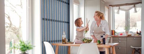 A 3D visualisation revealing a wall heating system installed in a kitchen where a mother and a child are cooking together.